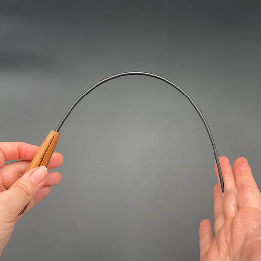 Mini Delrin Cane in hand, showcasing its flexibility and wooden handle, perfect for swinging.