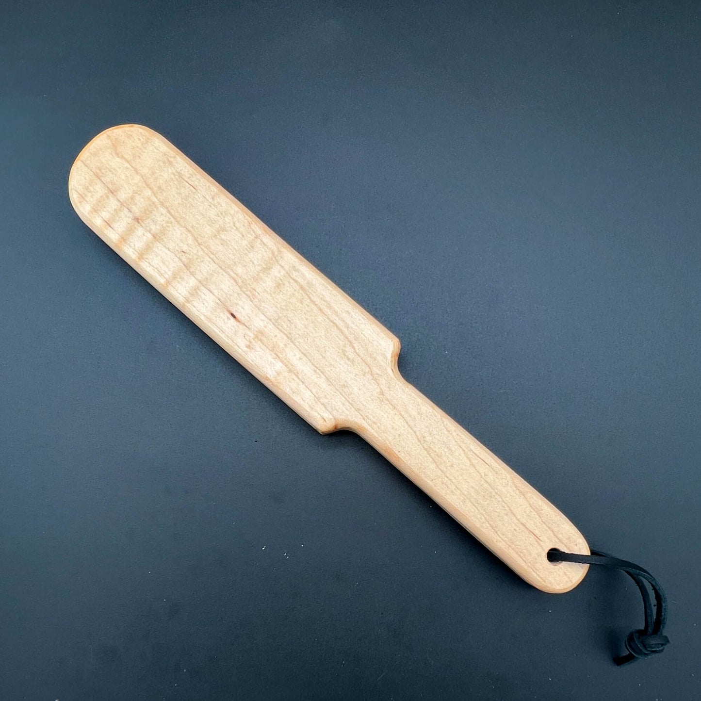 Pounder wooden paddle, 12 inches long, finished with natural wax, showcasing beautiful wood grain.