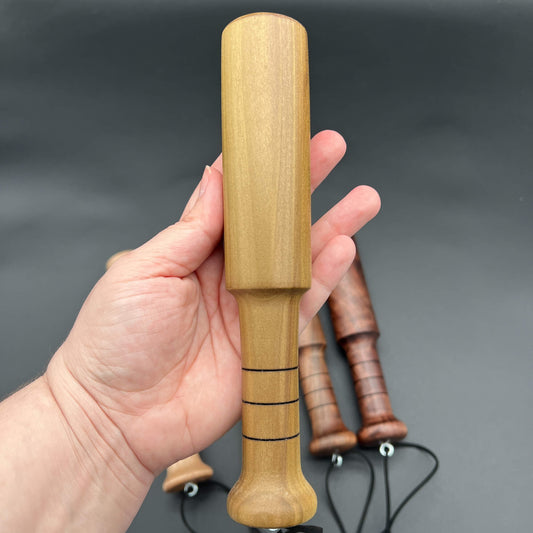 Mini Thumper, a small thuddy paddle held in hand, highlighting its compact design and unique thuddy impact.