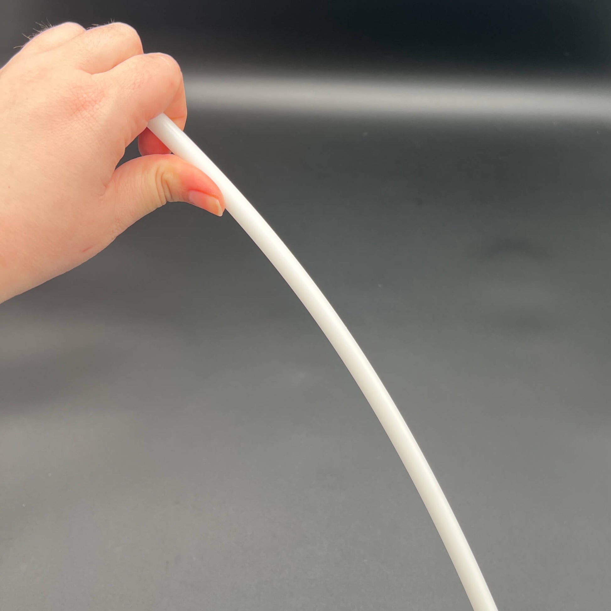 Hand holding a flexible 3/8 Inch Delrin Cane with Exotic Wood Handle, showcasing its sturdy design.