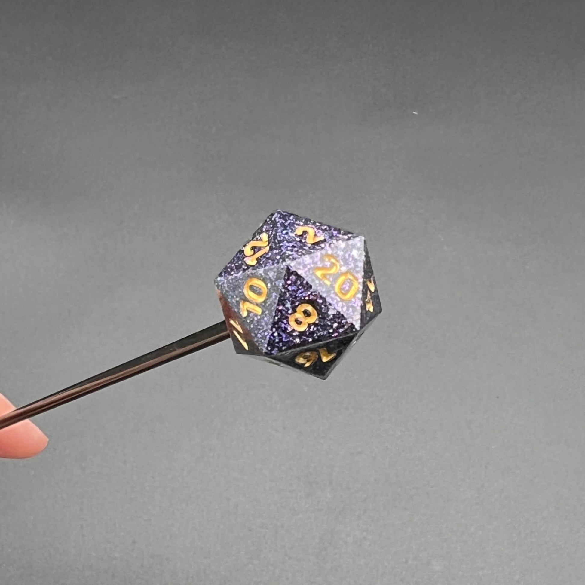 D20 Diabolical Sticks with a glittery purple handle with gold numbers for kink and TTRPG enthusiasts.