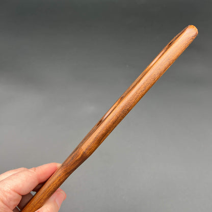 Hand holding a unique wooden paddle called Holy Terror, designed for impactful sensations.