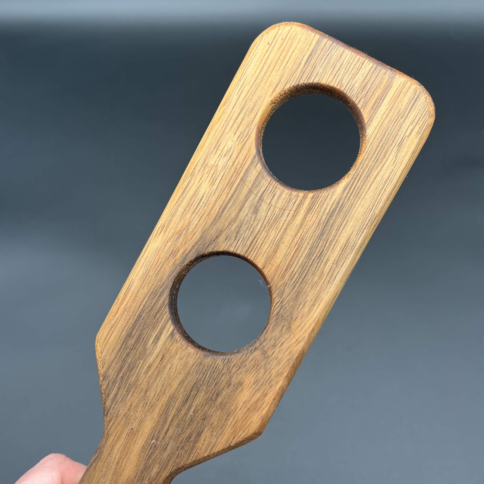 Holy Terror wooden paddle with two holes, designed for striking impact and sensory experiences.