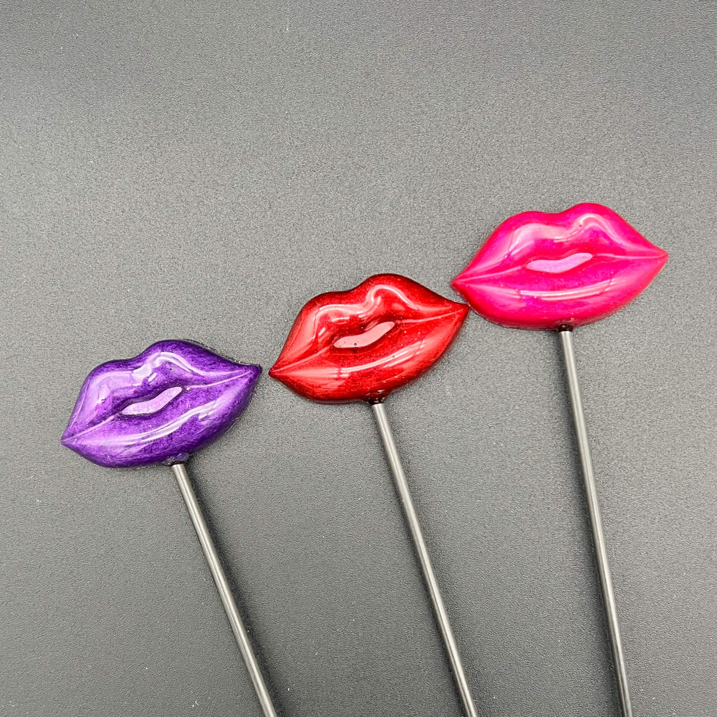 Lips Diabolical Sticks in purple, red, and pink colors showcasing playful resin lips on hand-turned sticks.