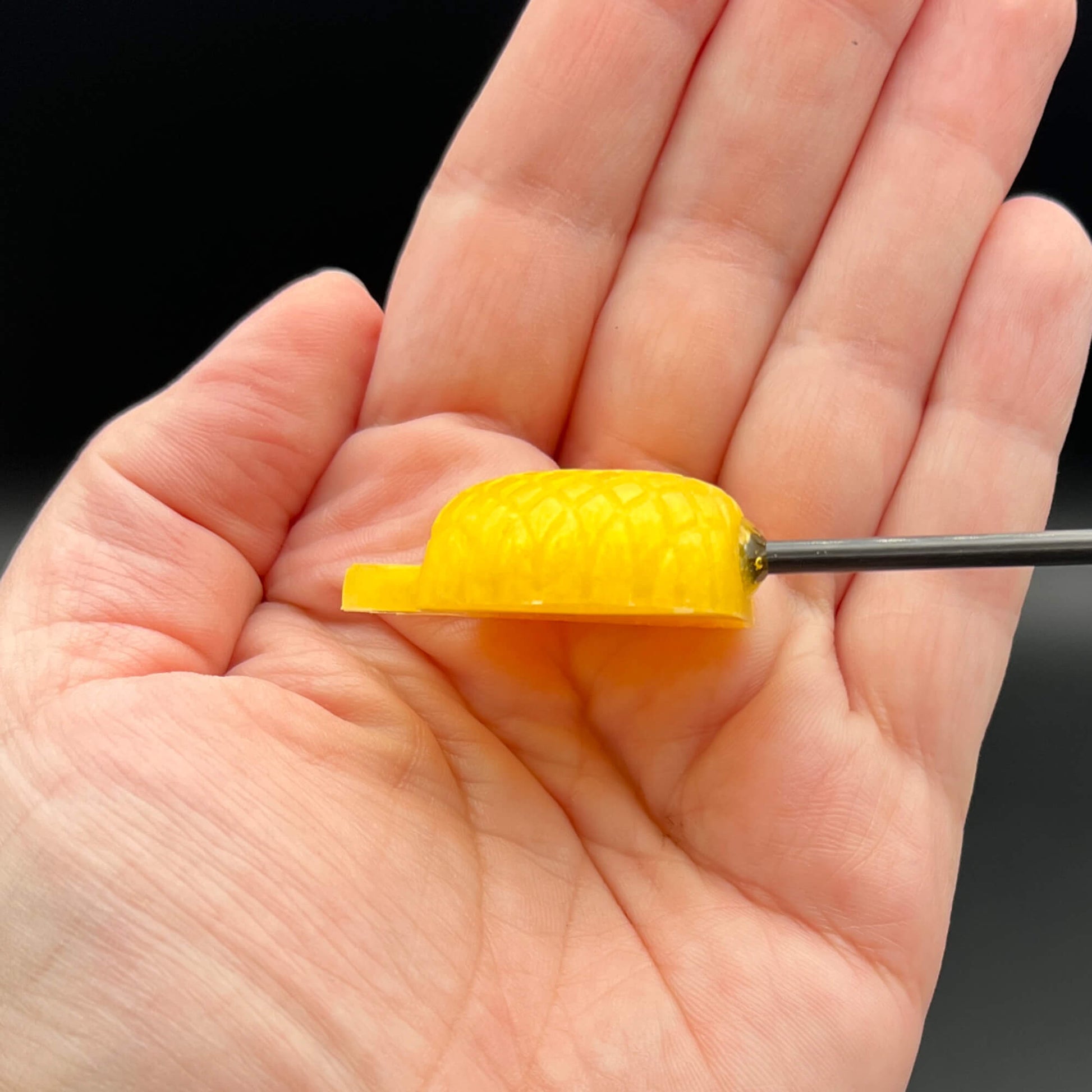 Pineapple Diabolical Sticks held in hand, featuring a sharp, yellow pineapple top, ideal for intense playful impact.