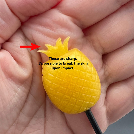 Close-up of a sharp Pineapple Diabolical Stick held in hand, showcasing its potential to break the skin upon impact.