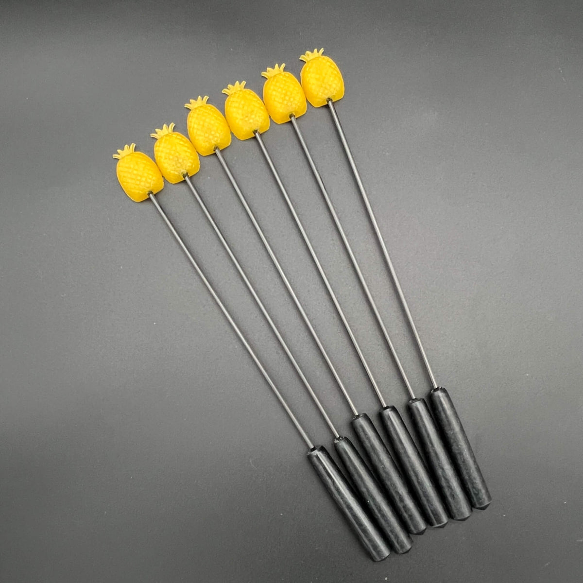Set of Pineapple Diabolical Sticks featuring yellow pineapples on a black handle.