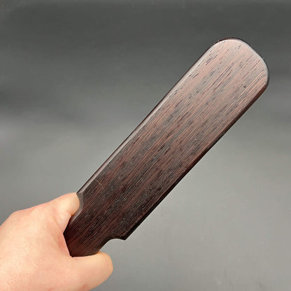 Pounder simple paddle made of dark almost black wood, 12 inches long and 2.25 inches wide, finished with natural wax.