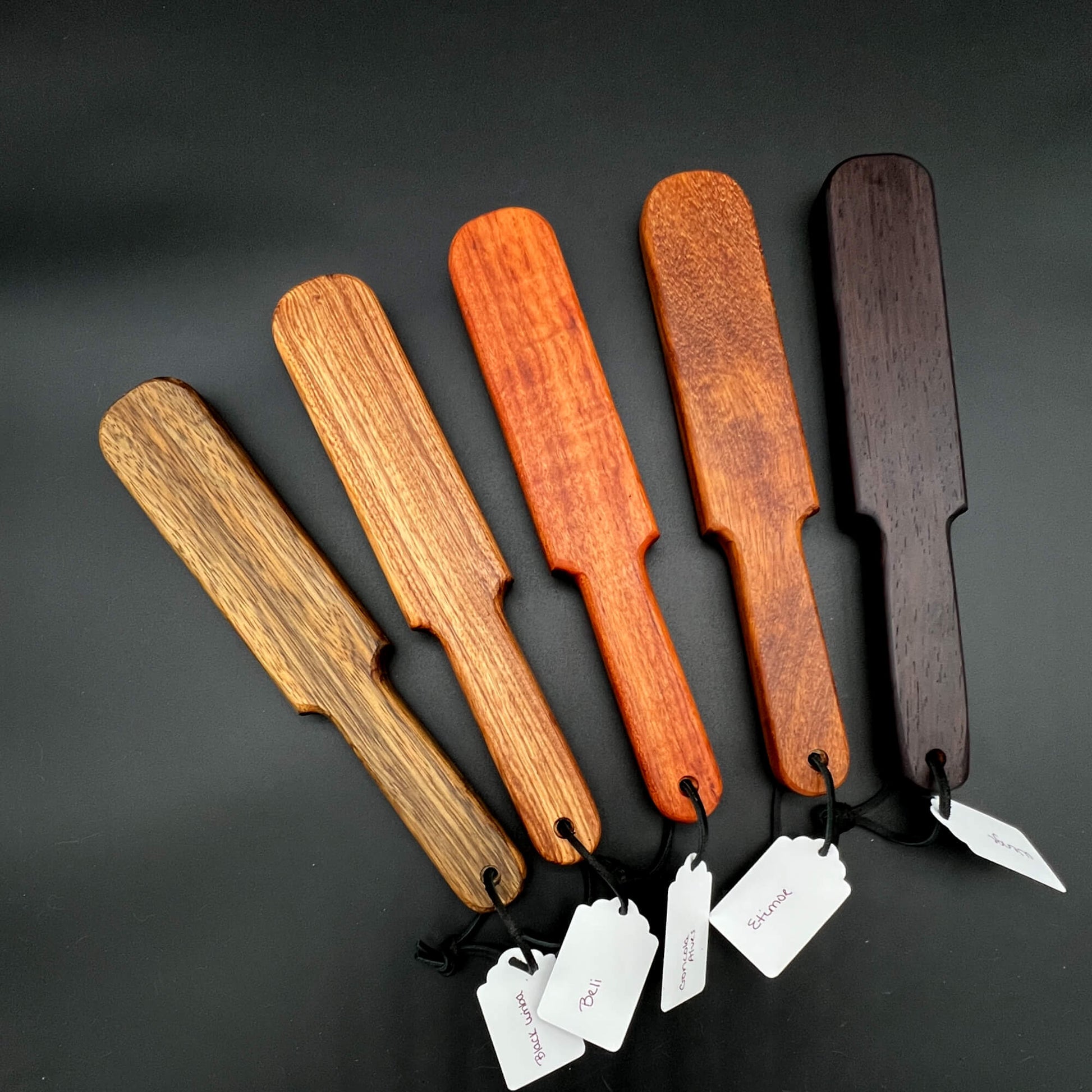 Pounder wooden paddles in various wood shades, simple paddle design measuring 12 inches long. Perfect for impactful use.