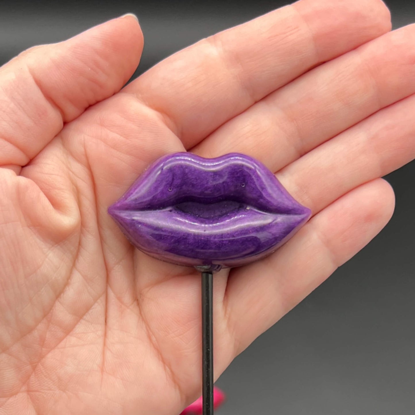 Lips Diabolical Sticks in purple held in hand, showcasing the bold design of the diabolical stick.