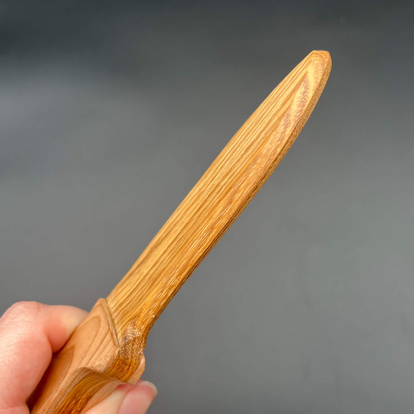 Spearpoint Wooden Knife held in hand, ideal for wax play and knife play with a genuine straight edge and sharp tip.