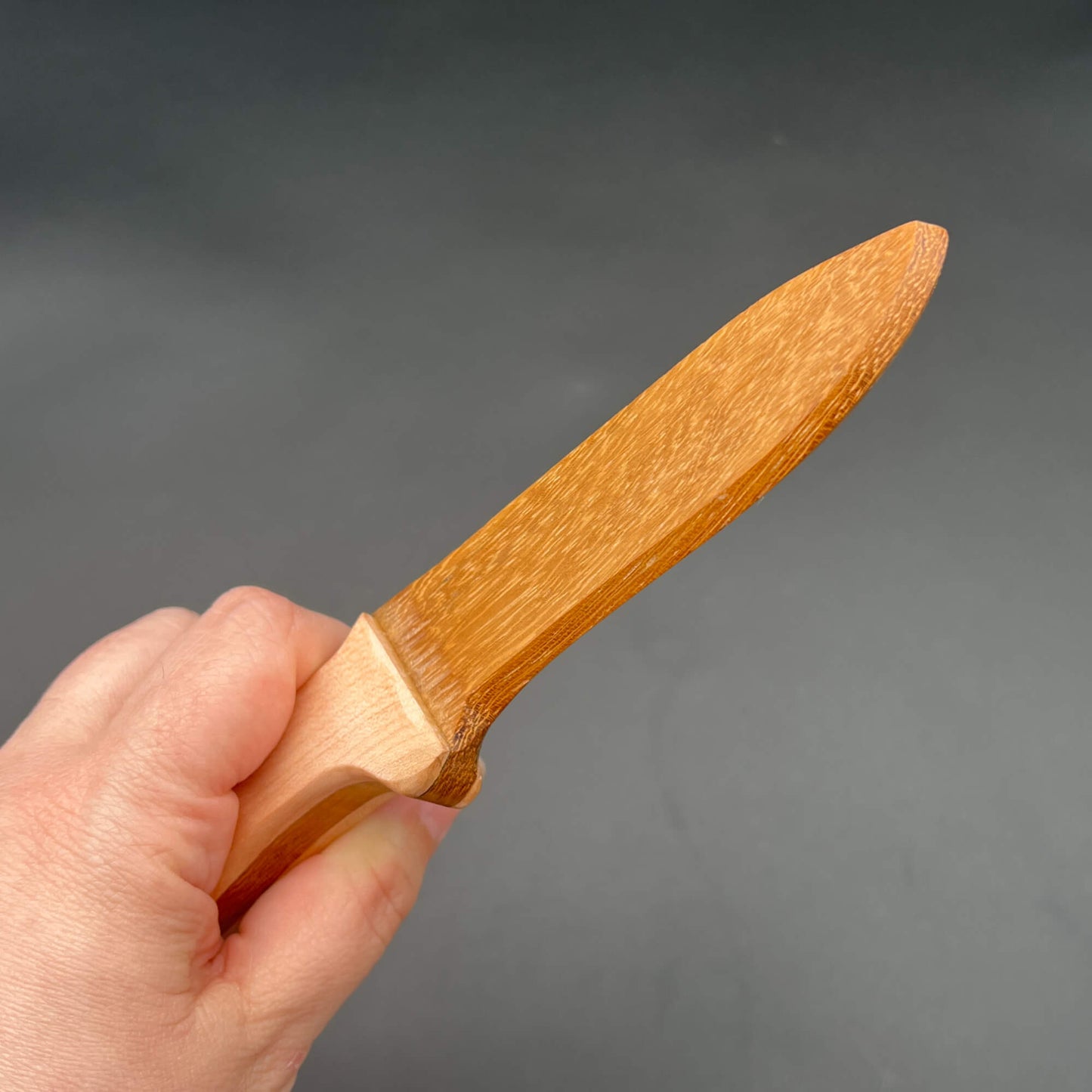 Spearpoint Wooden Knife held in hand, perfect for wax play and safe knife play scenarios.