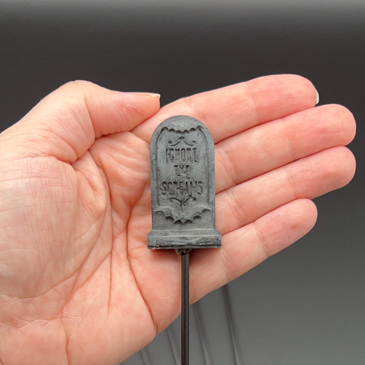 Tombstone Diabolical Stick, featuring 'Ignore the Screams' tombstone design in hand.