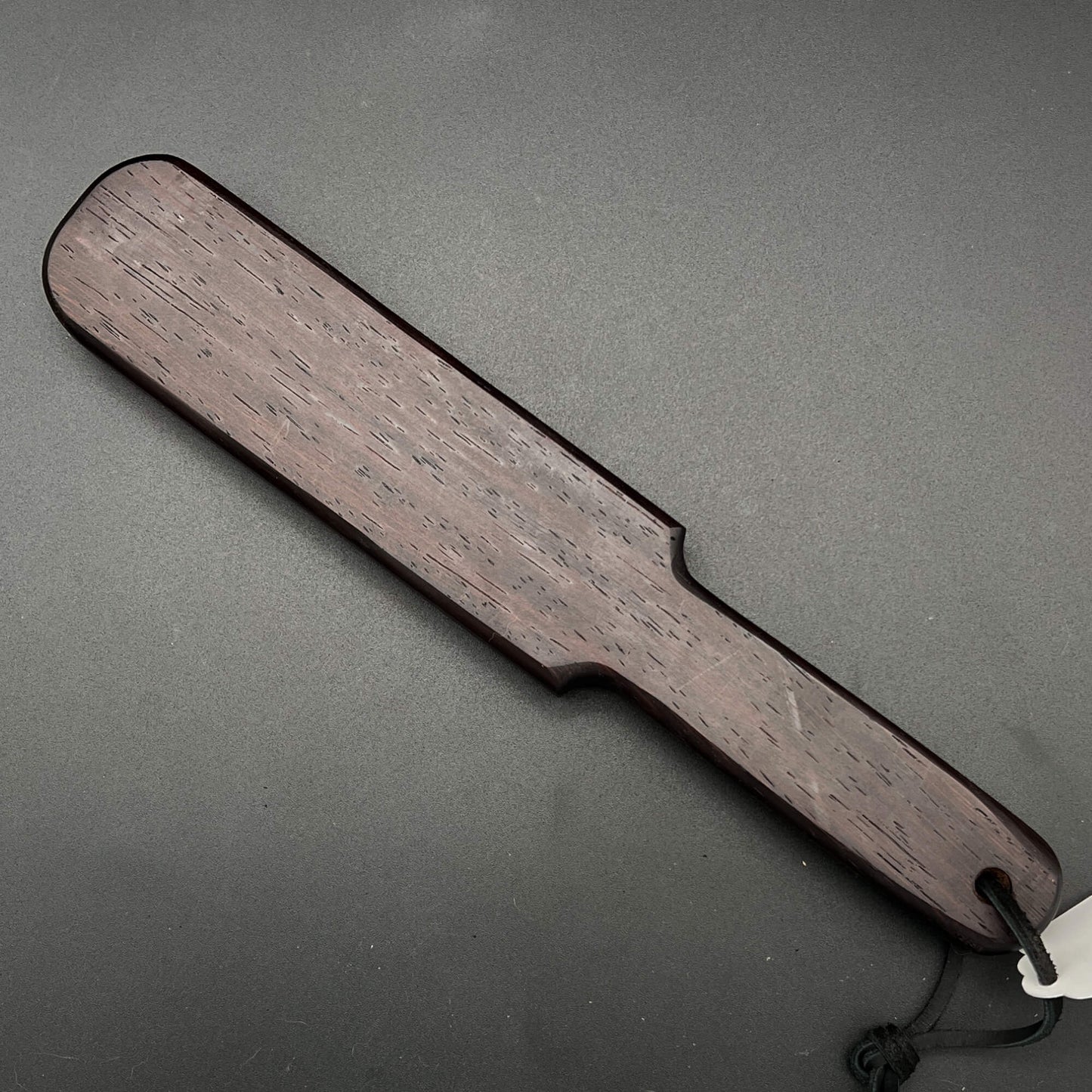Pounder wooden paddle in rich dark brown color, 12 inches long, 2.25 inches wide, a simple paddle that packs a punch.