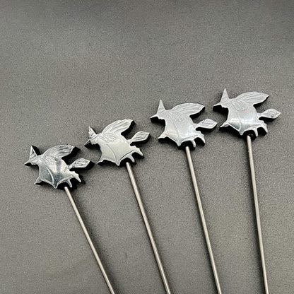 Close up of sharp-edged witch designs made with black resin and attached to 3mm carbon fiber rod