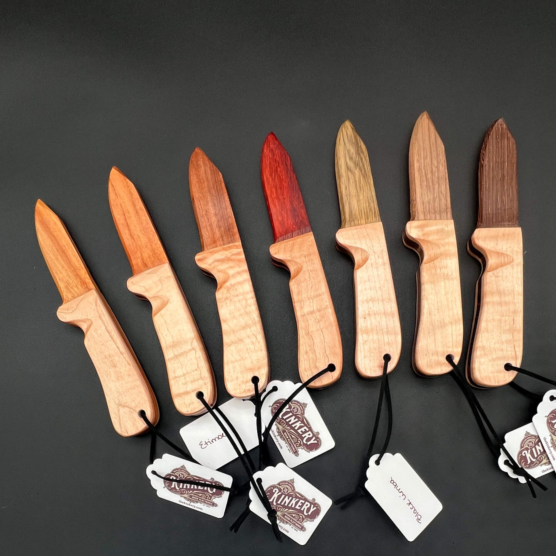 A variety of Wooden Wax Play Knives in different wood finishes, perfect for knife play and wax removal.