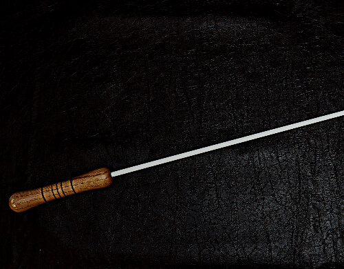 single quarter inch delrin cane on dark brown leather background
