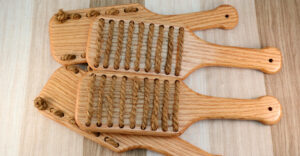cropped image of four Rough Rider paddles, two facing up to show lines of hemp rope, two facing down to show knots of rope in the wooden paddle