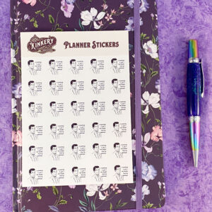 sheet of spanking is a one-handed round of applause planner stickers on top of purple floral planner next to turquoise pen on purple background