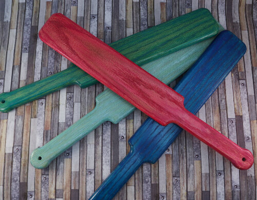 four pop-o-color large paddles in pink, turquoise, aqua, and blue over wooden background
