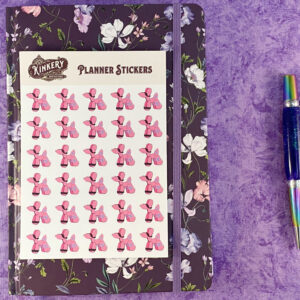 sheet of pink bondage balloon animal planner stickers on top of floral purple planner next to turquoise pen on purple background