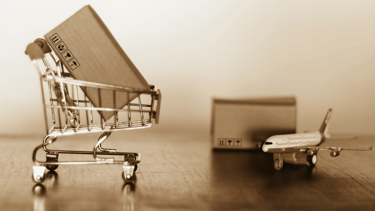 box in shopping cart and box next to airplane as concept for international shipping