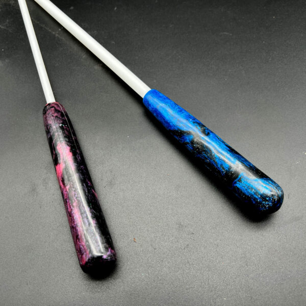 Examples of delrin canes with resin handles. On the left, 1/4 inch cane with pink and black resin. On the right, 3/8 inch cane with blue and black resin