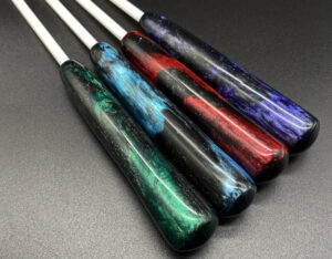 four 1/4" white delrin canes with resin handles; colors from left to right: green and black, blue and black, red and black, and purple and black