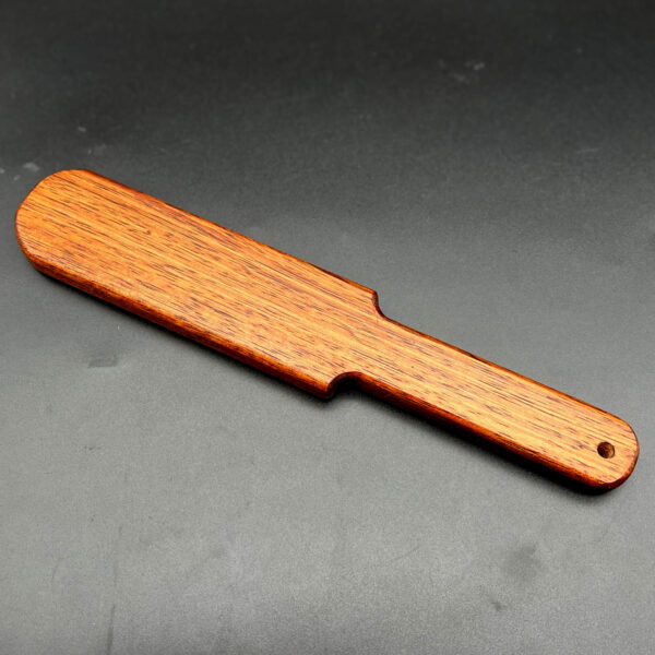 wooden paddle made with African Mahogany, a red brown wood with a vertical grain pattern in darker brown.