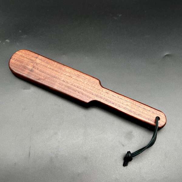 wooden paddle made of Black Walnut a deep dark brown wood with a vertical grain pattern in darker and lighter browns