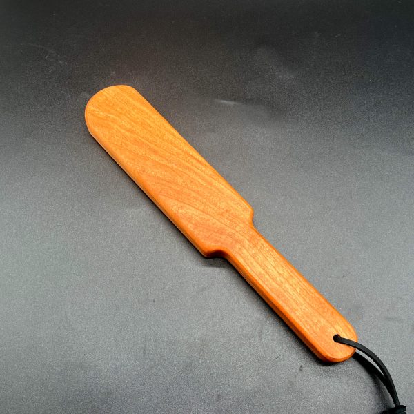 Wooden paddle made of cherry wood, a red-orange wood