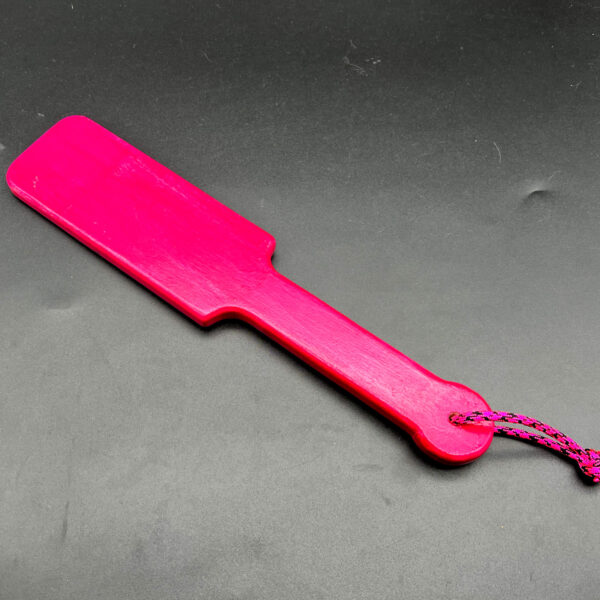 Small wooden paddle stained hot pink