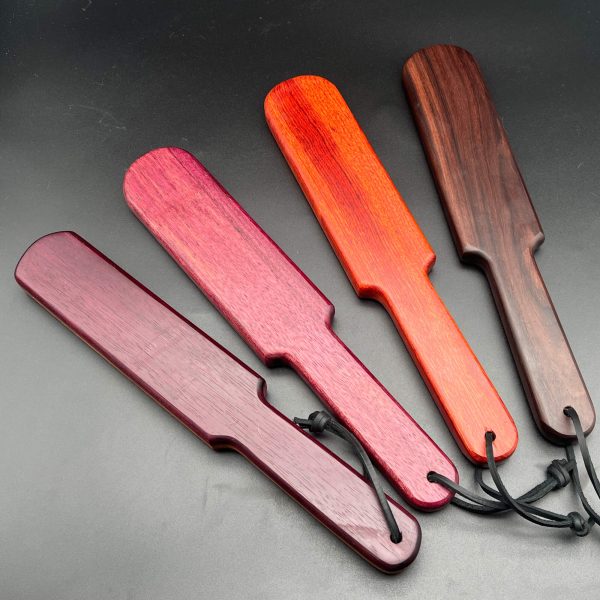 Four different types of Pounder paddles. Left to right: Purpleheart laminant, purpleheart, bloodwood, rosewood