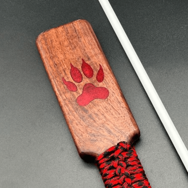 Close up of red wolf paw resin inlay in black walnut wood