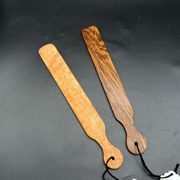 Two slapsticks side by side. The one on the left is made of Maple, a light brown wood. The one on the right is made of Bocote, a dark brown with a nearly black grain pattern.