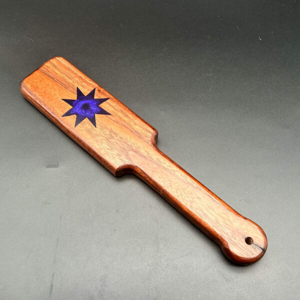 small black walnut paddle with purple 8-point star in the center