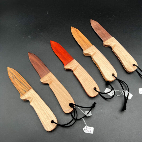 An array of wooden knives, all made with maple handles and different woods for the blades. From left to right, the woods are: Bocote, Rosewood, Paduak, Olive wood, and Black Walnut