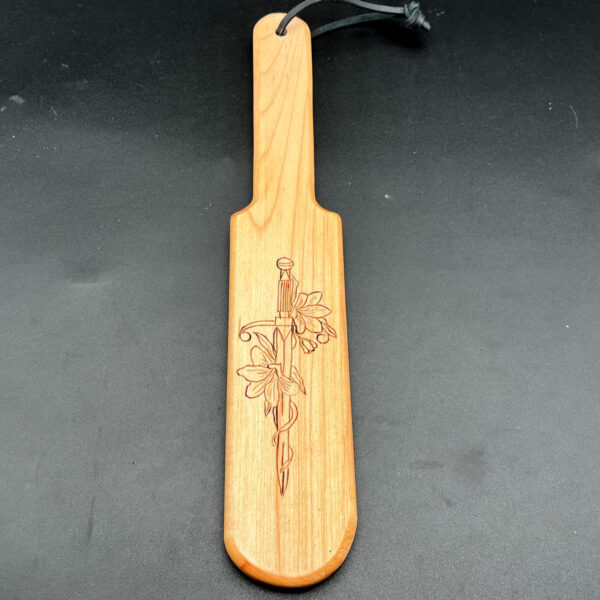 Pounder style paddle made of maple with sword and flowers wood burned into center of paddle