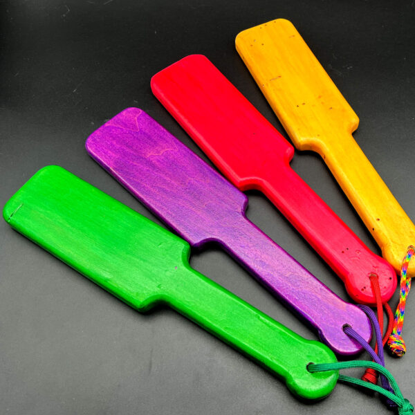 Multiple sparkle glitter pop-o-color paddles. From left to right: green, purple, red, and yellow