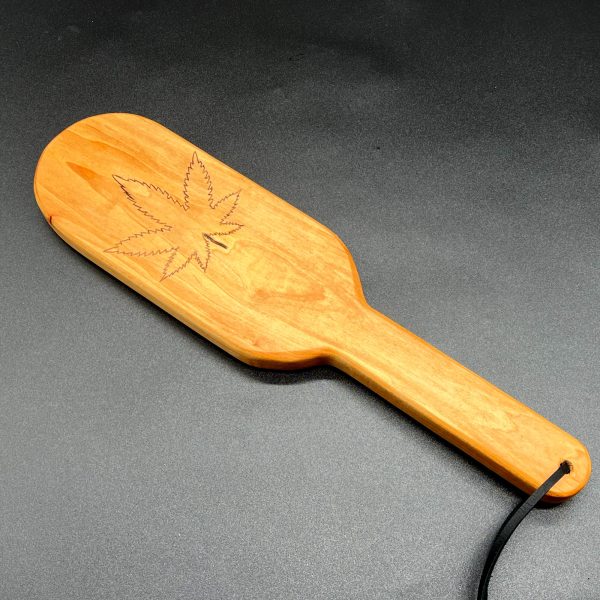 A 12 inch long wooden paddle with an outline of the devil's lettuce burned into the center of the paddle area. The paddle is 7 inches long and is in an oval shape. The handle is 5 inches long, 1.25 inches wide, and straight with no curves.