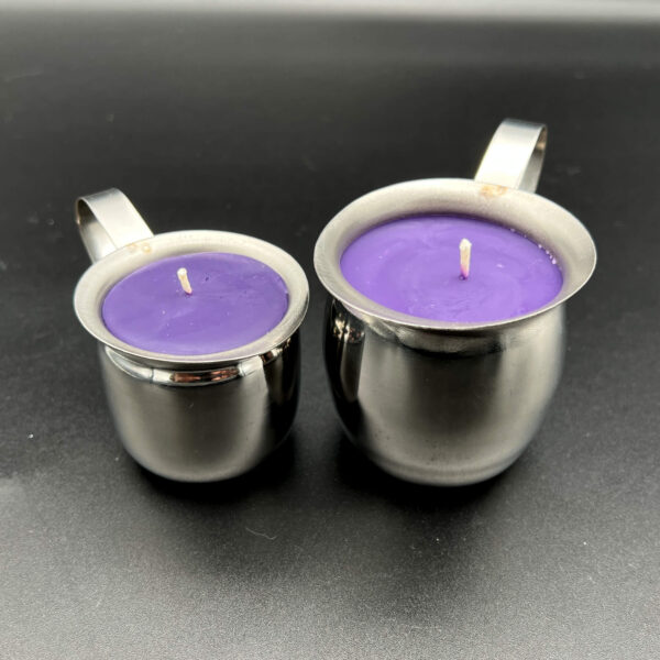 Two purple soy wax play candles in silver containers. The small (3oz) is on the left and the large (5oz) is on the right. The containers are silver creamer pots with handles.