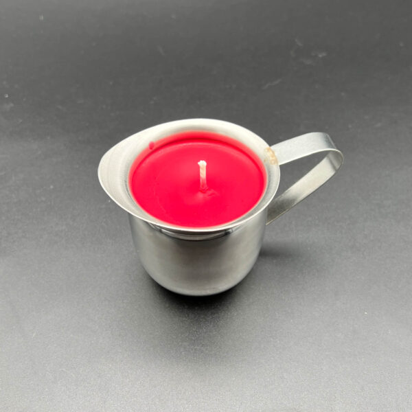 Overhead/side view of single red soy wax play candle in silver container with handle