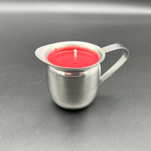 Side view of single red soy wax play candle in silver container with handle