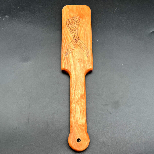 Small wooden paddle made of birch with mermaid tail wood burned into center