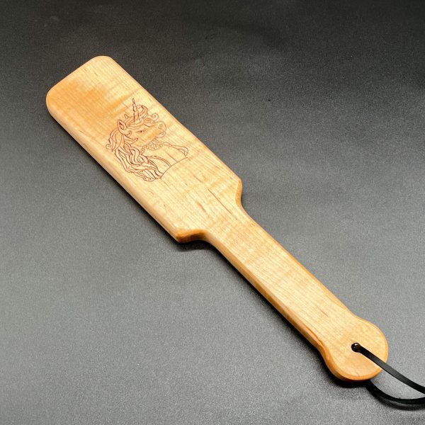 A 12 inch long wooden paddle with the side profile of a unicorn's head burned into the wood. The paddle is 6 inches long and is in an oval shape. The handle is 6 inches long and 1.5 inches wide.