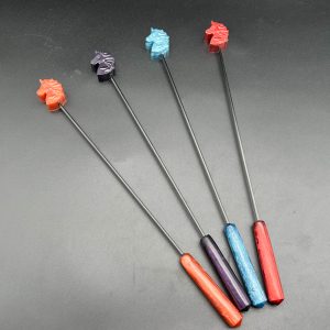 Four unicorn head diabolical sticks. From left to right: rose gold, purple, blue, red