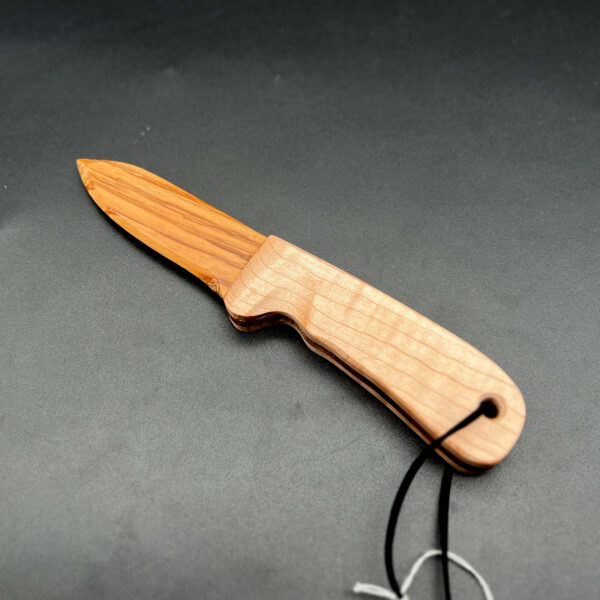 wooden knife made with zebrawood for the blade. This is a yellow-brown wood with a dark brown vertical grain pattern; the handle is made with maple, a light, white-yellow wood.