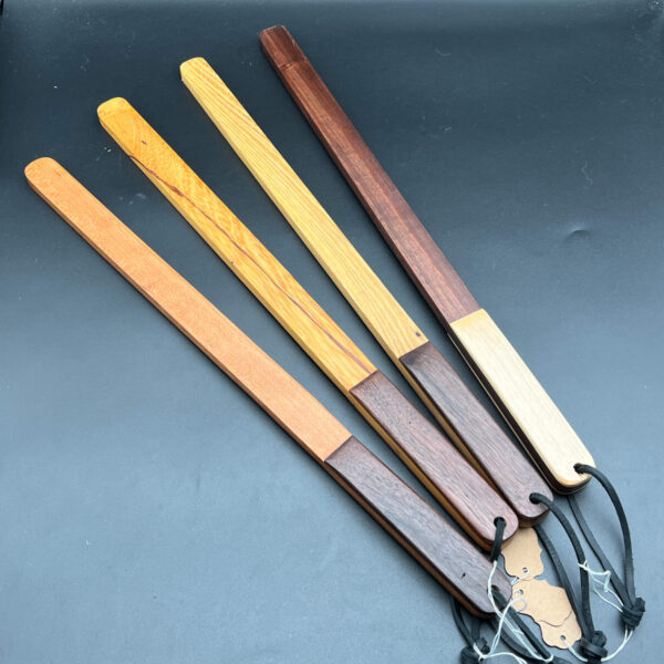 Group of four thick sticks - long, narrow paddles made in a variety of woods with laminated handles. From left to right: cherry, honey locust, black locust, and black walnut