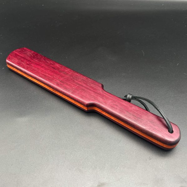 Pounder made with two types and three pieces of wood. Two pieces of thin purpleheart are on the outside, and in the center of the paddle is maple wood. It's sandwiched together in a lamination process.
