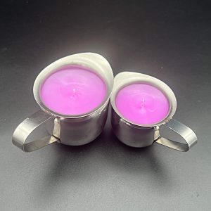 5 ounce (left) and 3 ounce (right) stainless steel container with pour spout and handle and 3 ounce container filled with pink paraffin wax for wax play
